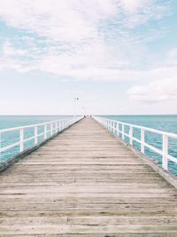 Empty pier on sea against sky