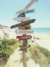 Information sign on beach against sky