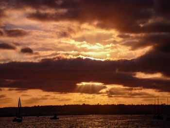 Scenic view of sea against dramatic sky during sunset