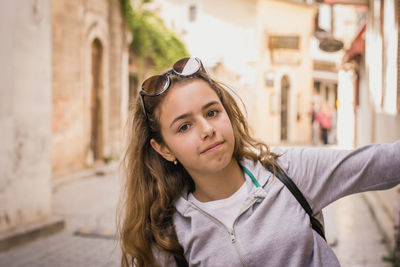 Portrait of girl wearing sunglasses standing in city