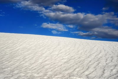 White sand dune in desert against blue sky