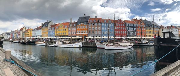 Panoramic view of boats in river against sky