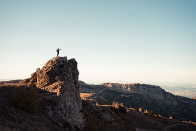 Man standing on cliff against clear sky