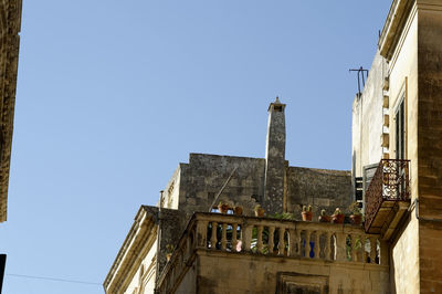 Low angle view of buildings against clear blue sky