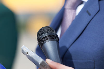 Close-up of midsection of politician with microphone