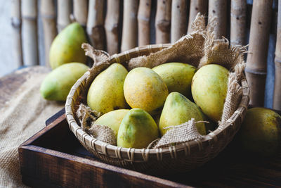 High angle view of mangoes with burlap in basket