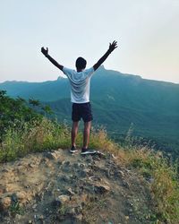 Full length rear view of man standing on mountain