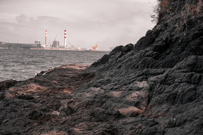 Rock formations on beach against sky