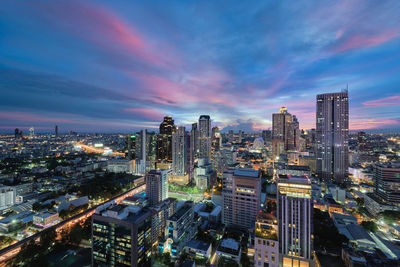 High angle view of city lit up at sunset
