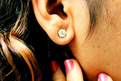 Cropped image of woman showing diamond earring