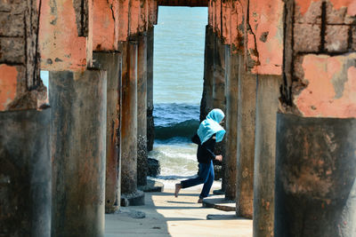 Woman amidst column at beach