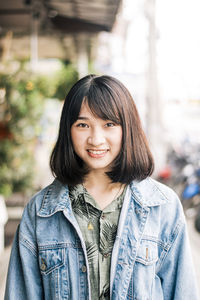 Portrait of smiling young woman standing outdoors