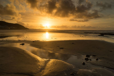 Scenic view of beach against sky during sunset
