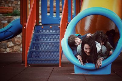 Portrait of happy boy on slide at playground