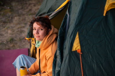 Young man sitting in tent