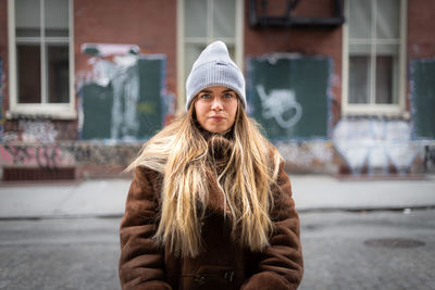 Portrait of teenage girl standing in city during winter