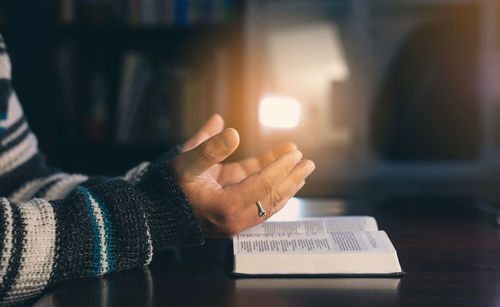 Midsection of woman holding hands with text on table