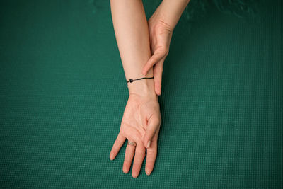 Close-up of woman hands on yoga mat