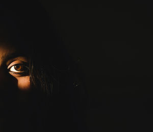 Close-up portrait of young woman in darkroom