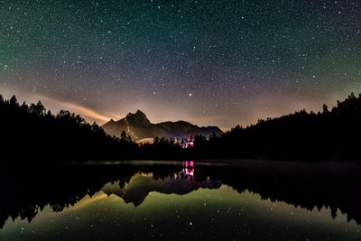 Night sky reflection in lake urisee with alps mountains in background