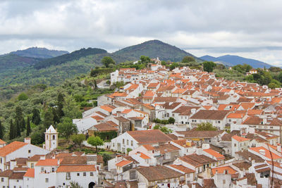 High angle view of houses in town against sky