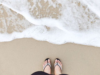 Low section of woman standing at shore