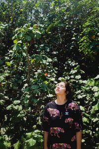 Young woman standing against trees