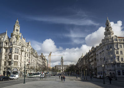 Panoramic view of buildings in town against cloudy sky