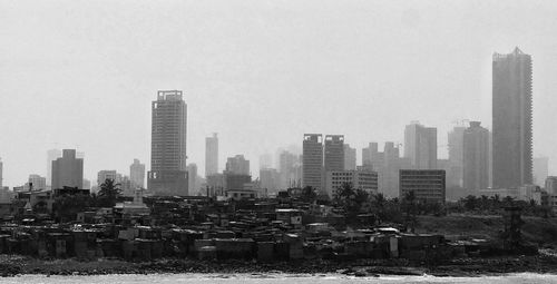 Buildings in city against clear sky