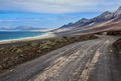 Road passing between coastline and mountains