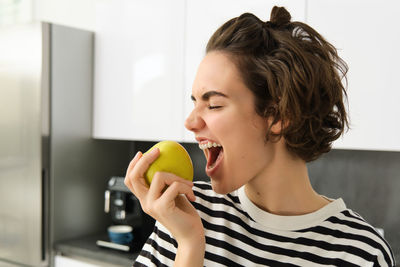 Young woman drinking juice at home