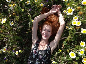 High angle view of smiling young woman lying on field