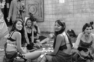 Happy friends standing against brick wall