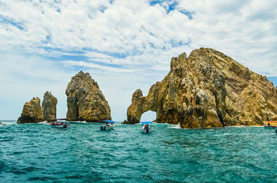 Rock formation in sea against sky