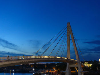 Low angle view of suspension bridge against blue sky