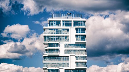 Low angle view of modern building against cloudy sky