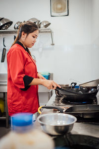 Side view of chef preparing food in kitchen