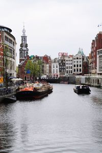 Boats in river with buildings in background