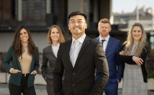 Portrait of business colleagues standing in city
