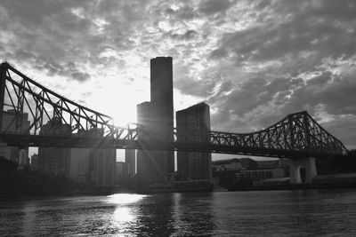 Bridge over river against sky in city