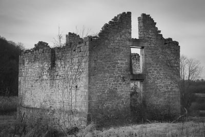 Old ruin building on field against sky