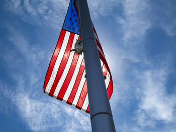 Low angle view of flag against blue sky