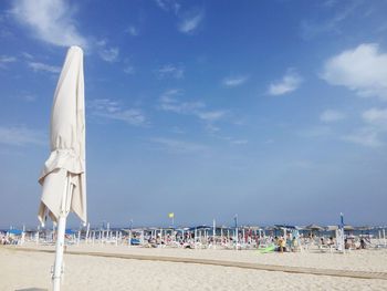 People at beach against blue sky