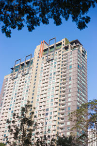 Low angle view of modern building against clear blue sky