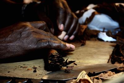 Cropped image of person making cigar