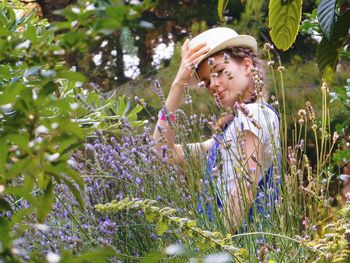 Young woman with pink flowers in garden