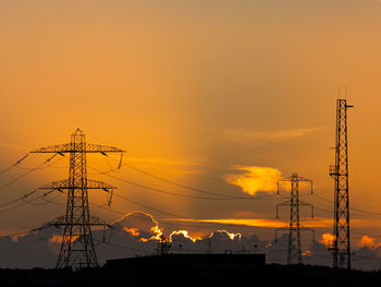 Low angle view of silhouette electricity pylon against romantic sky