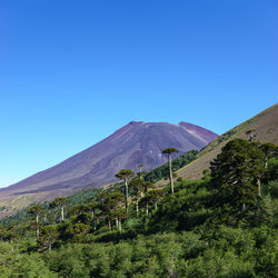 Scenic view of mountains against clear blue sky