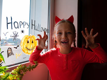 Child painting pumpkin window preparing celebrate halloween kid draws decorates room with paper bats