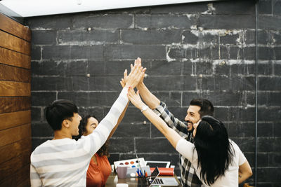 Colleagues giving high-five in office